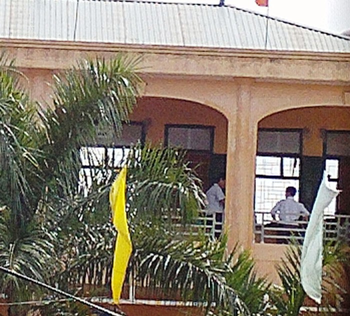 Nhân viên Kế Toán trường Đồi Ngô Nguyễn Văn Dũng đứng trao đổi với 1 số giám thị trước hành lang giờ thi toán.